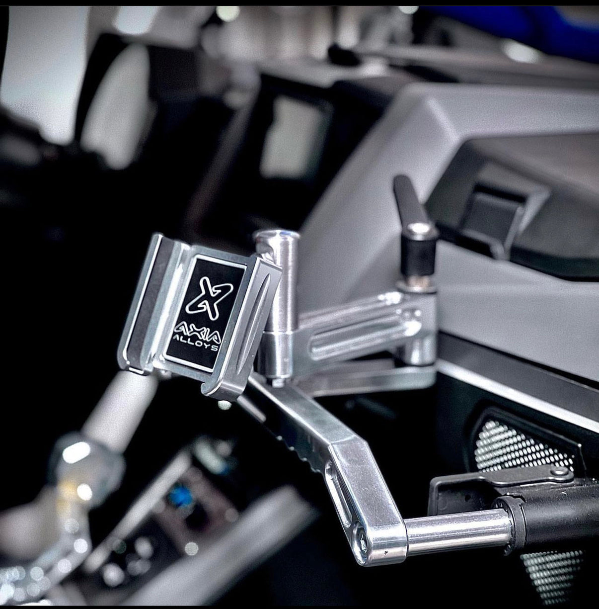 Axia Alloys Cell Phone Holder Adapter mounted on a UTV steering wheel, designed for off-road usage and easy accessibility.