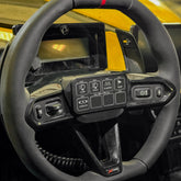 Switch-Pro Steering Wheel Mount for Maverick R installed on steering wheel in UTV, featuring controls for off-road accessories.
